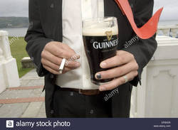 man-drinking-a-pint-of-guiness-stout-beer-and-holding-a-cigarette-DFBXD9.jpg