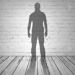 31752604-Shadow-of-a-man-on-white-brick-wall-and-wooden-floor-Stock-Photo.jpg
